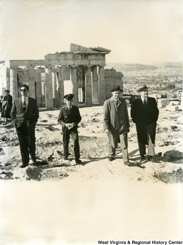 Congressman Arch A. Moore, Jr. talking with an unidentified man as they walk away from the Parthenon in Athens, Greece.  Two other unidentified men are walking with them; one appears to be a officer.