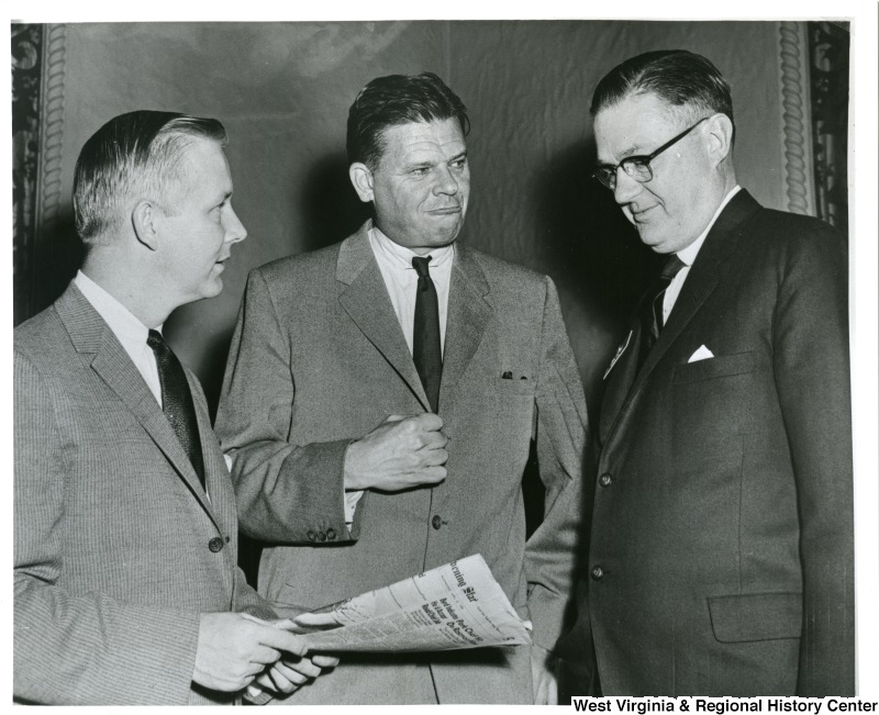 Congressman Arch A. Moore, Jr. holding a newspaper and talking to Congressman Thruston B. Morton (center) of Kentucky and an unidentified congressman.
