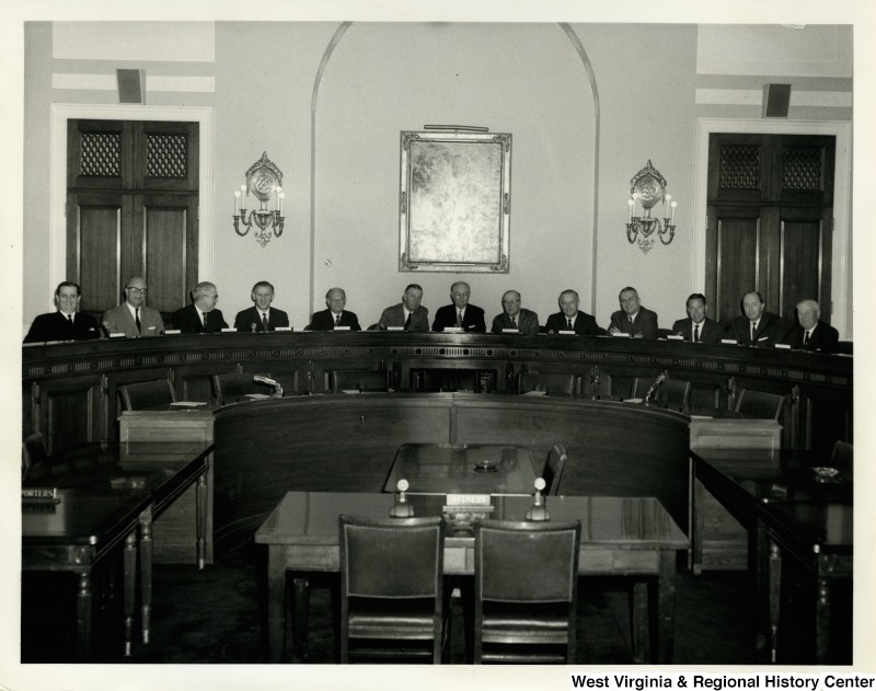 Congressman Arch A. Moore, Jr. with other congressmen in a hearing room. From left to right: Dale Alford, unknown, Tom Steed, unknown, Abraham Multer, Joe L. Evins, Emanuel Celler, William M. McCulloch, Arch A. Moore, Jr., unknown, H. Allen Smith, William Cahill, and unknown.