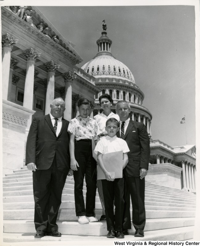 Congressman Arch A. Moore, Jr. standing on the steps of the Capitol Building with a family of four.