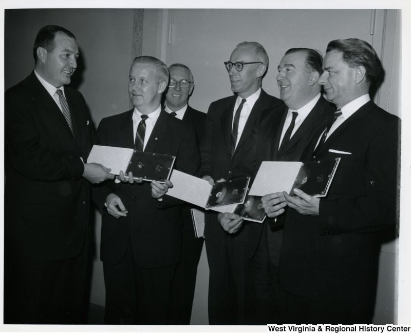 Congressman Arch A. Moore, Jr. holding a plaque and standing with members of the West Virginia delegation. From right to left: Senators Robert C. Byrd,  Jennings Randolph, Congressmen Ken Hechler, unknown, Arch A. Moore Jr., unknown.