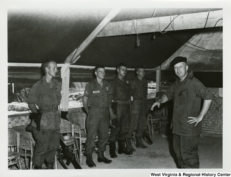 Congressman Arch A. Moore, Jr. speaking to four members of the U.S. Army in Vietnam.