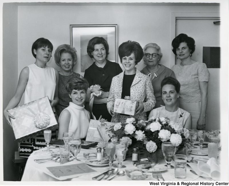 An unidentified group of women, most likely Congressman Moore's staff members, holding gifts at Suzi's shower.