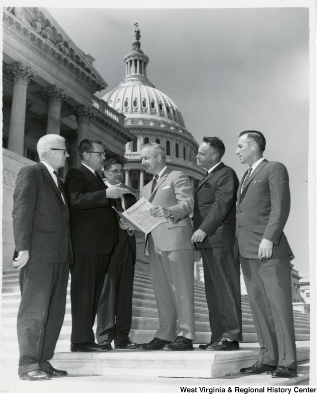 West Virginia mailmen asking Congressman Arch A. Moore, Jr. to help carry the mail on a legislative proposal to ease size and weight restrictions on parcel post packages. From left to right: Clyde Olver and Robert F. Glassgow of Wheeling; R.B. Smith of Wallace; Congressman Moore; Albert Moore and Walter W. Williams of Clarksburg.