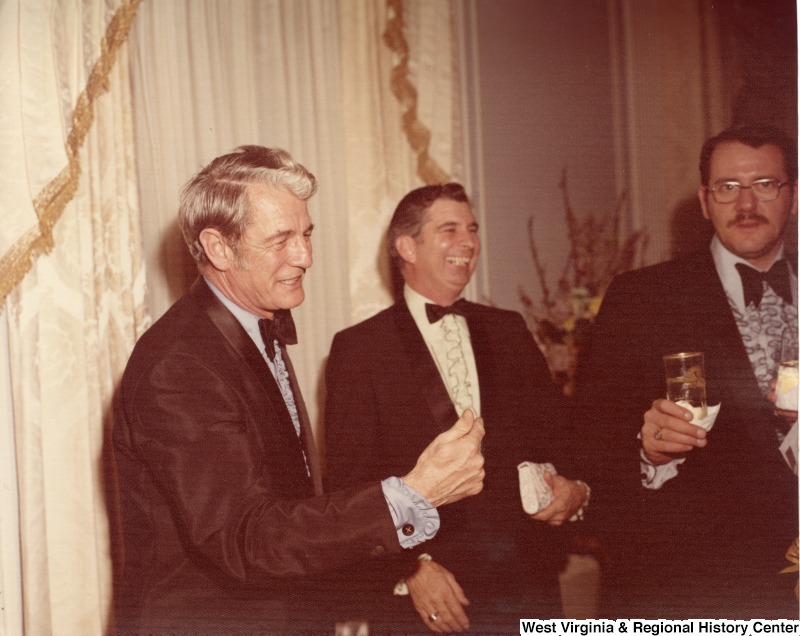 Three unidentified men talking at a reception.