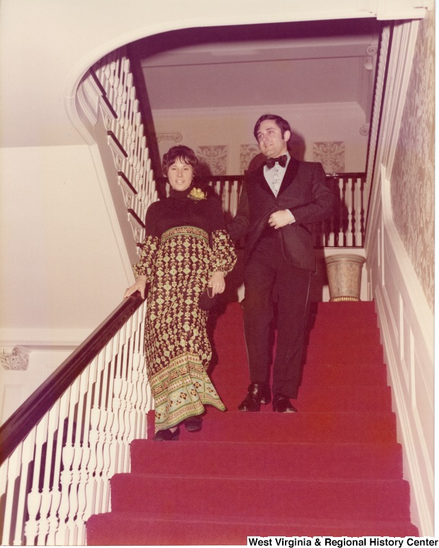 An unidentified man and woman walking down the stairs at a reception.