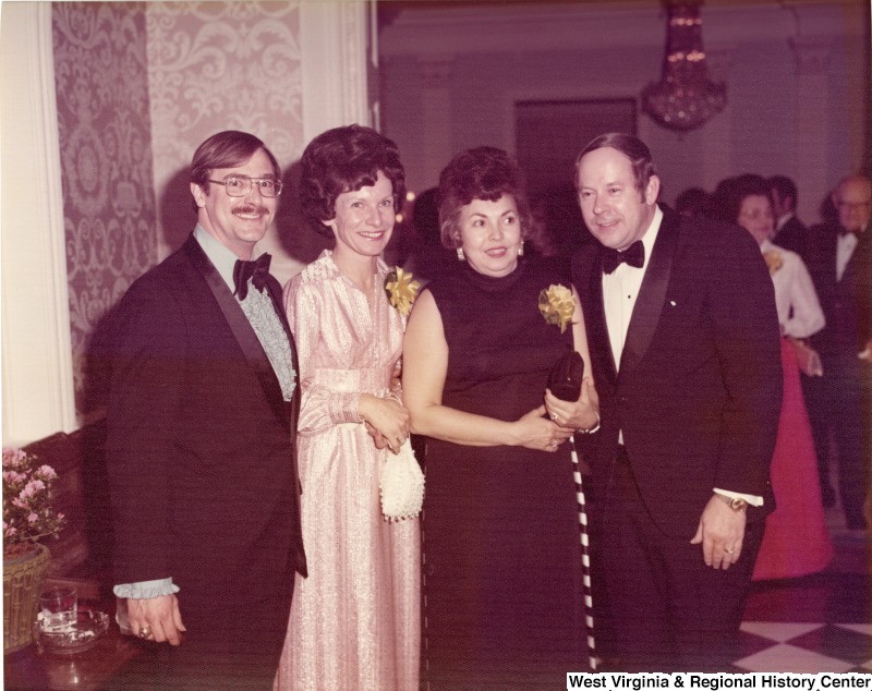 Two women and two men posing for a photo at a reception.