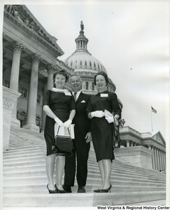 Congressman Arch Moore, Jr. and two unidentified women standing on the steps of the Capitol Building.