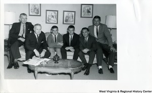 Congressman Arch A. Moore, Jr. sitting on a couch with Robert K. "Bob" Holliday and four other unidentified men.