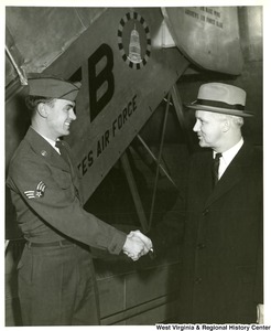 Airman Marion L. Mussili shaking hands with Congressman Arch A. Moore, Jr.  immediately after their arrival at MATS (Military Air Transport Service) terminal, Andrews AFB (Air Force Base), Maryland from Europe. Congressman Moore interceded in the confinement of Airman Mussili by the Greek Government after his conviction for hitting a pedestrian with a military vehicle. Moore then brought the airman back to the states with him.