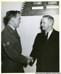 Congressman Arch A. Moore, Jr. shaking hands with Airman Marion L. Mussili after their arrival at MATS (Military Air Transport Service) Terminal, Andrews Air Force Base, Maryland from Europe. Moore interceded in the confinement of Airmen Mussili by the Greek Government after his conviction for hitting a pedestrian with a military vehicle. Moore then brought the airman back to the states with him.