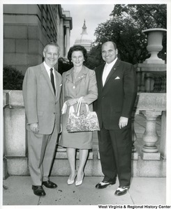 Congressman Arch A. Moore, Jr. (left) standing with his wife, Shelley Moore, and an unidentified man. The Capitol Building can be seen in the background.
