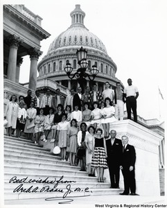 Congressman Arch A. Moore, Jr. with an unidentified group of men and women on the steps of the Capitol. The photograph is signed "Best wishes from Arch A. Moore, Jr. "
