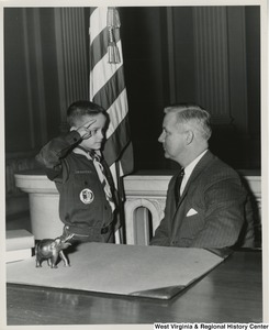 Congressman Arch A. Moore, Jr. getting saluted by an unidentified Cub Scout.