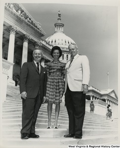 Congressman Arch A. Moore, Jr. standing with an unidentified woman and man on the steps of the Capitol.