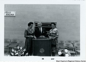 Congressman Arch A. Moore, Jr. standing at a podium with two unidentified women.