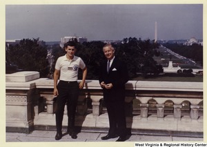 Congressman Arch A. Moore, Jr. standing with an unidentified man. The Washington Monument is in the background.