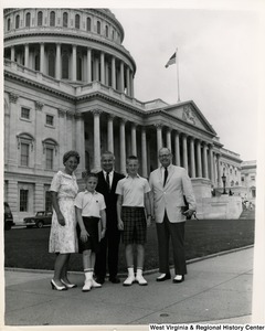 Congressman Arch A. Moore, Jr. standing with an unidentified family of four in front of the Capitol Building.