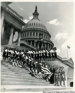 Congressman Arch A. Moore, Jr. standing on the steps of the Capitol with a group of Girl Scouts from Troops 260, and 241.  Some of the girls are holding a American Flag.