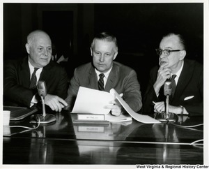 Congressman Arch A. Moore, Jr. with two unidentified men from the House Ways and Means Committee. They are going over a document.