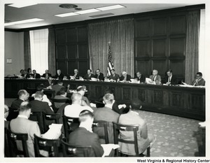 Congressman Arch A. Moore, Jr., seated third from the right, speaking during a meeting.