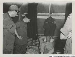 Congressman Arch A. Moore, Jr. and Mr. Garner J. Cline, Counsel Committee on the Judiciary, House of Representatives, talking to Chaplain (Captain) Hutchens wounded in action with the 173rd Airborne Brigade at the 3rd Mobile Army Surgical Hospital (MASH), Bien Hoa, Vietnam.