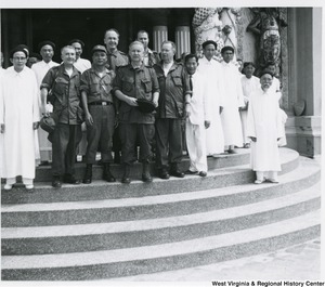 Congressman Arch A. Moore, Jr. standing on the steps of the Cao Dai Temple with an unidentified group of men.