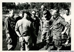 Congressman Arch A. Moore, Jr. standing with a group of soldiers in Vietnam.