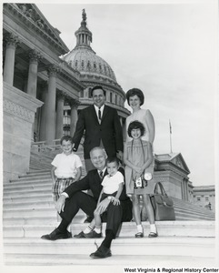 Congressman Arch A. Moore, Jr. on the steps of the Capitol with Victor Sreco? and family. Moore is sitting with one of the children on his lap.
