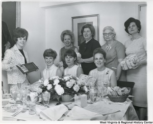 An unidentified group of women, most likely Congressman Moore's staff members, holding gifts at Suzi's shower.