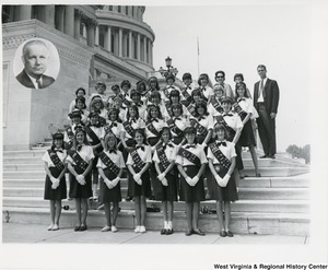 The Wheeling Girl Scouts standing on the steps of the Capitol. A portrait of Congressman Arch A. Moore, Jr. has been added at to the top left corner of the photograph.