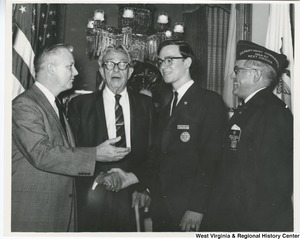 Richard A Robinson, Winner of the State Veterans of Foreign Wars annual Voice of Democracy contest, shaking the hand of Senator Everett McKinley Dirksen. Left to right: Congressman Arch A. Moore, Jr.; Senator Everett Dirksen; Richard Robinson from Fairmont, W.Va.; and State Department Commander Emmett Williams of Beckley.