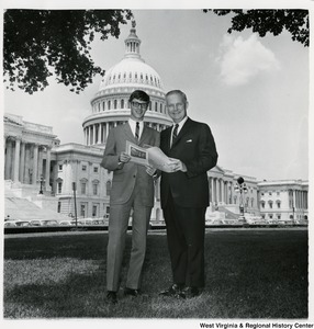 Congressman Arch A. Moore, Jr. standing on the lawn of the Capitol with Lawrence Crawford. They are holding a document.