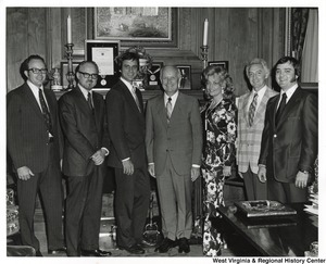Governor Arch Moore (center) standing with five unidentified men and one woman.