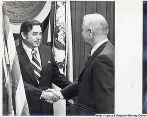 Governor Arch Moore shaking the hand of an unidentified man.