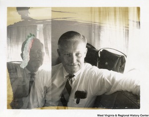 Governor Arch Moore on a flight with Cathay Pacific Airways. The photograph has been double exposed and there is damage around it.