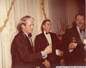 Three unidentified men talking at a reception.