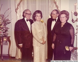 Two unidentified men and two unidentified women at a reception.