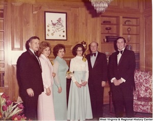 Three unidentified men and three unidentified women at a reception.