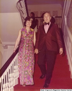 An unidentified man and woman walking down the stairs to a reception.