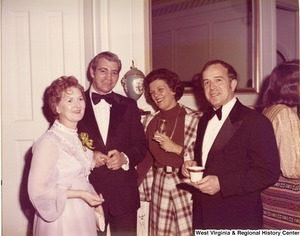 Two men and two women posing for a photo at a reception.