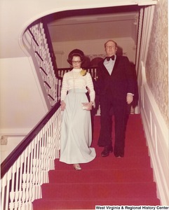 An unidentified man and woman walking down the stairs at a reception.