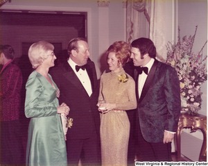 Two men and two women having a conversation at a reception.