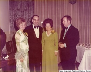 Two women and two men posing for a photo at a reception.