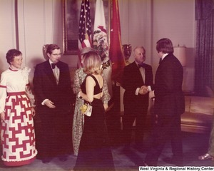 An unidentified man is shaking the hand of Governor Arch Moore. An unidentified woman is speaking to Shelley Moore and an unidentified man and woman at a reception.