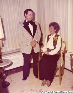 An unidentified man and woman at a reception. The woman is sitting.
