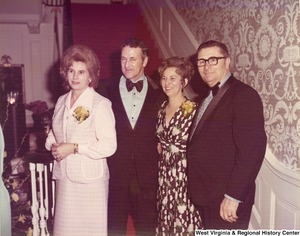 Two men and two women posing for a photo at a reception.