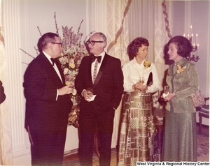 Two men and two women having a conversation at a reception.