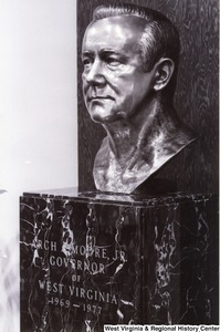 A bronze bust of Governor Arch Moores face. On the stand of the bust it reads Arch A. Moore, Jr. Governor of West Virginia 1969-1977.