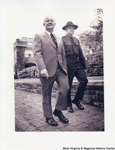 Governor Arch Moore walking on a sidewalk with an unidentified police officer.